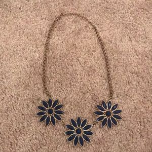 A gold necklace with blue crystal flowers